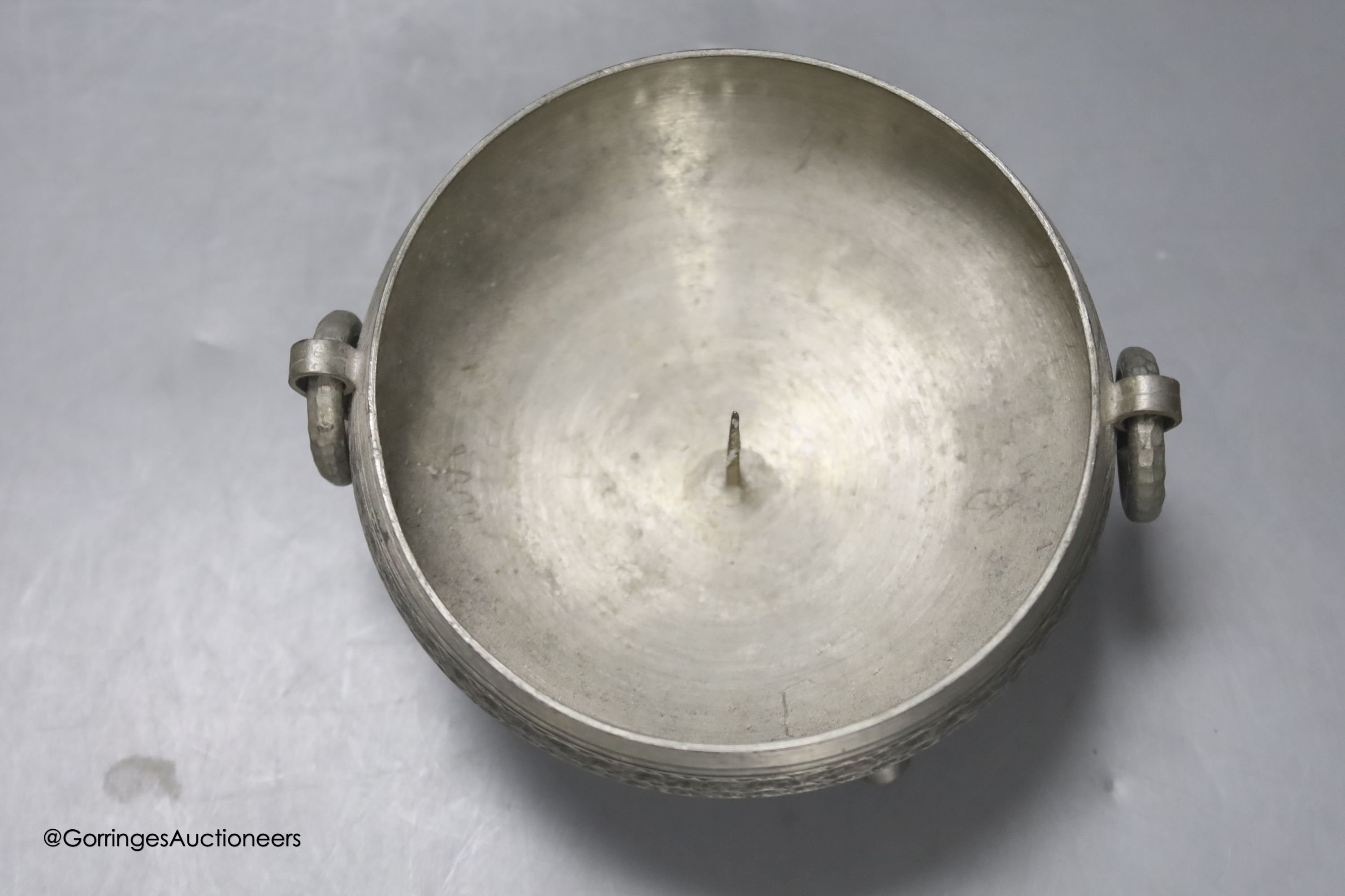 A Liberty & Co Tudric pewter pin dish, a Tudric covered jug and a pewter candleholder
